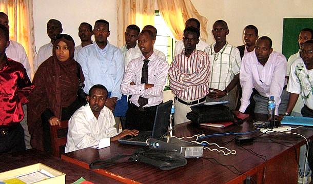 A group discussing teaching around a laptop and projector in Somaliland.